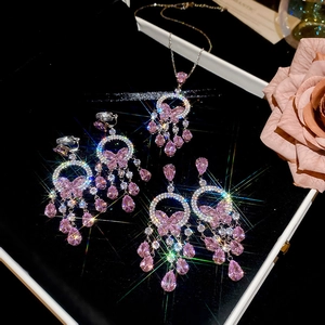 Detail of pink crystal necklace set with butterfly tassels and shimmering rhinestones