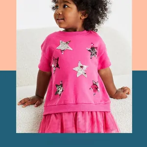 Detail of girls rose pink sequined star dress with layered mesh skirt and warm jersey bodice