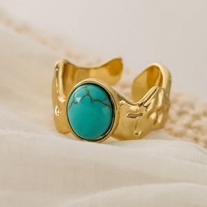 Close-up of 18K gold plated wide band ring with turquoise stone and hammered texture