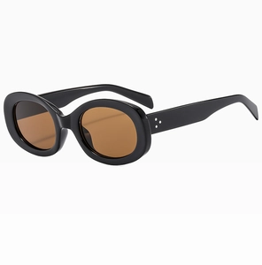 Detailed side view of oval sunglasses with silver triple-rivet hinges and amber lenses