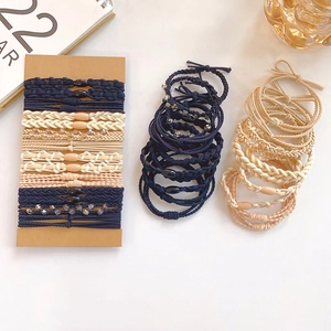 Elastic hair tie set in navy, cream, and nude colors featuring braided and beaded designs