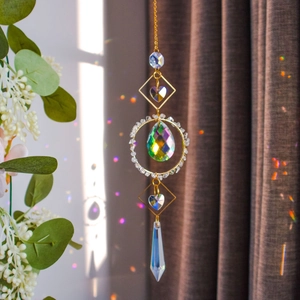 Close-up of rainbow teardrop crystal pendant reflecting colorful light on a neutral background