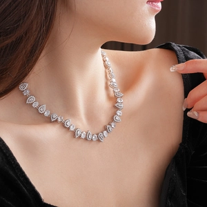 Detailed view of silver zircon water drop necklace on model with black velvet dress