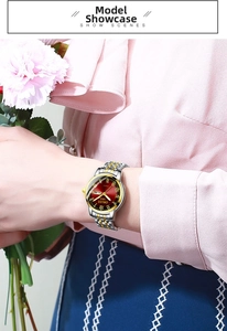 Detail of elegant ladies quartz watch with red dial and gold markers on a silver-gold strap