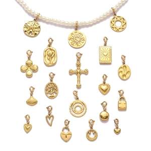 White pearl necklace set with diverse gold-plated stainless steel charms on white background