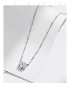 Dettaglio macro del ciondolo in moissanite rotonda argento con catena a croce
