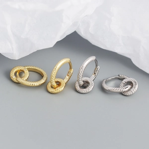 Detailed view of intertwined double hoop earrings with twisted rope texture in gold and silver