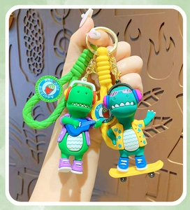 Detail of cute dinosaur keychains with braided ropes, guitars and skateboards