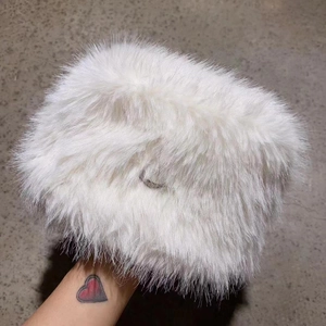 Detail showing plush white faux fur texture of a thick winter bucket hat being held