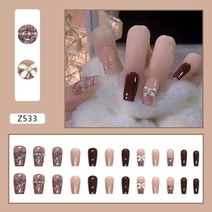 Deep brown Chanel-style press-on nails with 3D bow, pearls and glitter accents