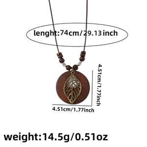 Detailed view of bohemian leaf pendant with wooden base including weight and size measurements