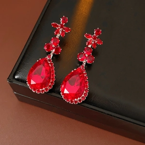 Detailed view of red drop-shaped zircon earrings with flower accents and crystal halo
