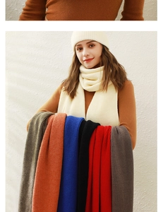 Detail von cremefarbenem Strickmütze- und Schal-Set mit verschiedenen Winter-Accessoires