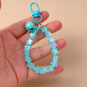 Detail of light blue star beads and a small bell on the creative acrylic keychain