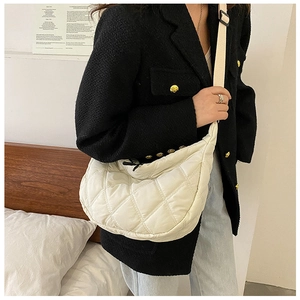 Close-up of white quilted crescent bag showing detailed stitching and nylon texture