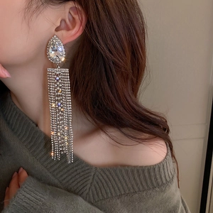 Close-up of sparkling rhinestone waterdrop tassel earrings worn on a female model