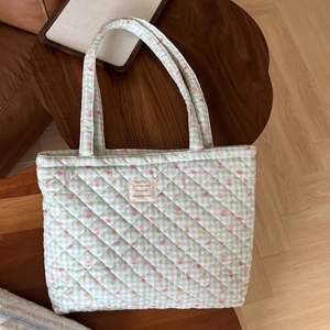 Detail of blue quilted cotton tote bag featuring tulip floral pattern on a wood table