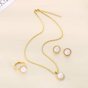 Elegant gold jewelry set with shell pearls and twisted details including necklace and ring