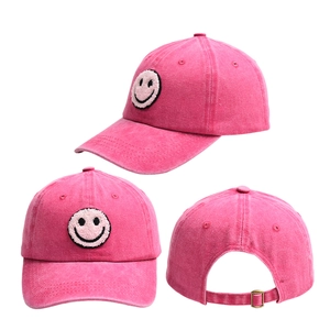 Detail of hot pink baseball cap showing smiley face towel embroidery and metal adjustment buckle
