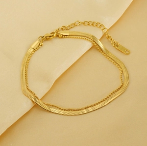 Close-up of double-layer 18K gold-plated snake and bead anklet on silk fabric