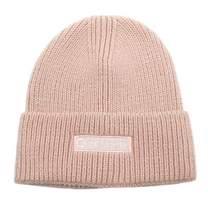 Detail of dusty pink knitted beanie showing ribbed texture and THE FOCUS patch