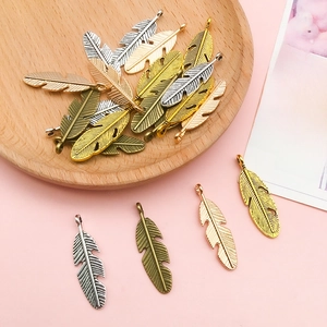 Macro detail of leaf feather alloy charms in various vintage metallic finishes for DIY