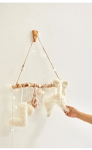 Detail of Christmas wall hanging with wood sticks, LED lights and knitted ornaments