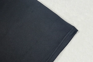 Detailed view of the dark blue knit dress hem featuring precise stitching and elastic fabric