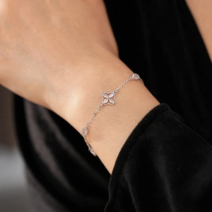 Detailed view of silver zircon flower bracelet on wrist with elegant velvet background