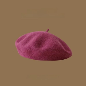 Close-up of premium burgundy wool beret fabric texture and vintage design details