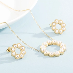 Dettaglio di parure collana e orecchini a ghirlanda dorata con perle incastonate