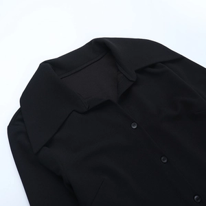 Détail du col à revers et de la fermeture à boutons sur robe chemise noire