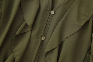Detail of olive green chiffon blouse featuring front buttons and ruffled texture