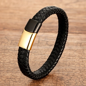 Braided black leather bracelet with dual-tone gold and black magnetic clasp on wood