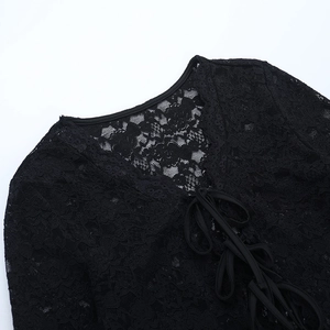 Close-up of black floral lace neckline with criss-cross lace-up ties on retro top