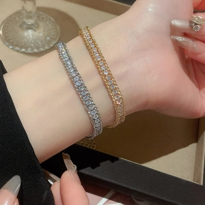 Close-up of adjustable rhinestone chain bracelet on wrist in gold and silver finish