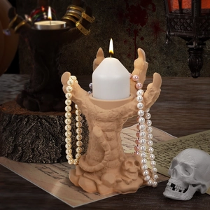 Skeleton hand candle holder used as jewelry storage for necklaces in gothic decor