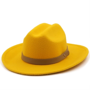 Detail of yellow wool felt fedora featuring a brown leather band and gold rivet detail