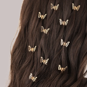 Mini gold butterfly hair clips for women on brown curly hair with hollow metal design
