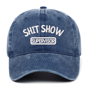 Detail of embroidered SHIT SHOW SUPERVISOR text on navy blue washed denim baseball cap