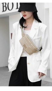 Detail of beige oxford waist bag showing dual zipper layers and adjustable strap