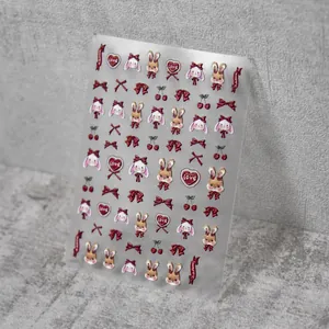Macro detail of embossed nail stickers featuring deep red bows and cute rabbit designs