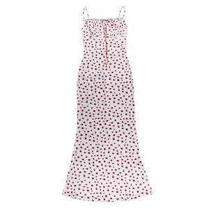 Detalle del vestido de verano blanco con flores, lazo ajustable y pequeñas flores rojas
