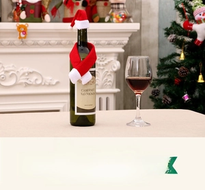 Détail d'un mini bonnet de Noël et d'une écharpe rouge et blanc pour décoration de bouteille