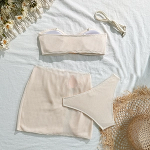Detailed flat lay of beige waffle texture three-piece bikini set with mini skirt