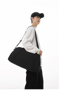 Versatile large capacity black sports gym bag for travel and fitness shown being carried