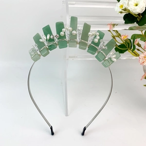 Detailed craftsmanship of handmade green crystal crown headband with pearls and rhinestones