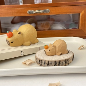 Cute wooden capybara desktop ornament with orange on head in cozy home setting