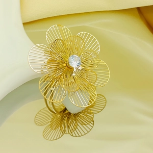 Detailed view of golden multilayer flower ring with center zircon and hollow wirework