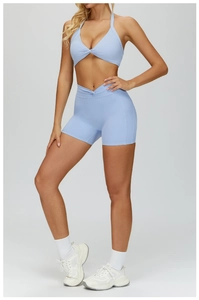 Close-up of light blue yoga set with twist-knot bra and crossover high-waist shorts